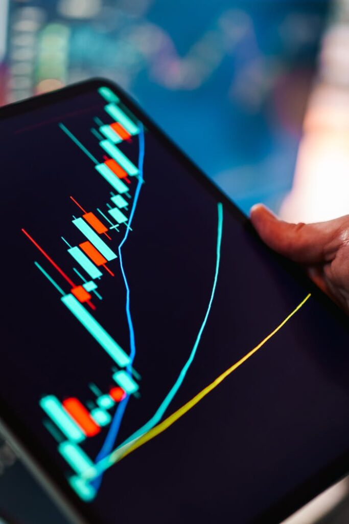 pexels-photo-35501928 A close-up of a tablet displaying a colorful candlestick chart, ideal for finance and technology themes.